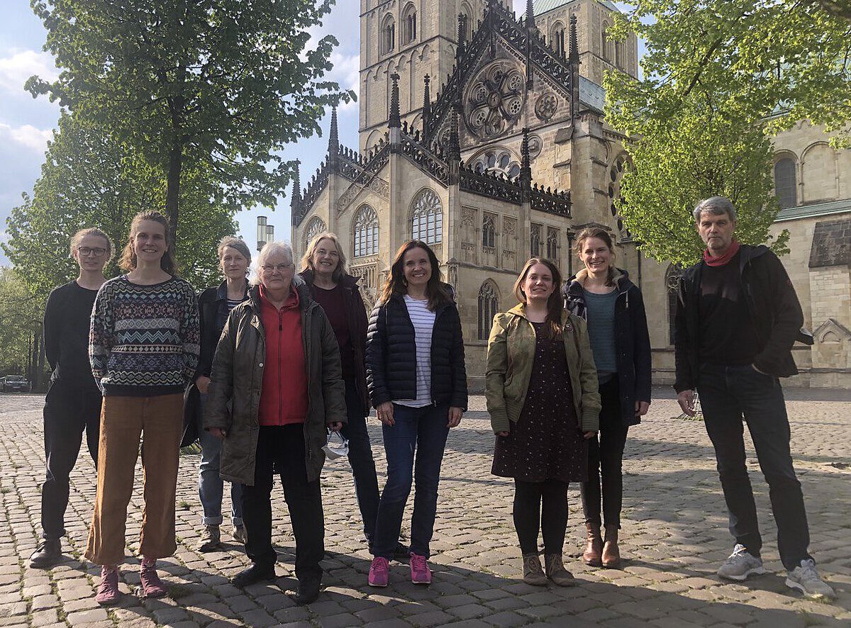 Das Foto zeigt einige Stadtführer und Stadtführerinnen des Netzwerks "SDG-Stadtrundgänge Münster" auf dem Domplatz in Münster